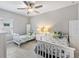 Comfortable bedroom features two twin beds, tile floors, a ceiling fan, and neutral gray walls at 4406 Rustling Pines Ter, Parrish, FL 34219
