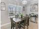 Well-lit dining area with view of screened patio and a modern light fixture at 4406 Rustling Pines Ter, Parrish, FL 34219