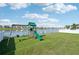 The backyard features a playset, artificial turf, a swing, and a view of the pond at 4503 Lindever Ln, Palmetto, FL 34221