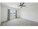 Bright bedroom featuring gray carpeting, a modern ceiling fan, and windows with a view at 4503 Lindever Ln, Palmetto, FL 34221