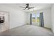 This bright bedroom features gray carpets, a ceiling fan and a window with neighborhood views at 4503 Lindever Ln, Palmetto, FL 34221