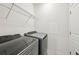 Bright laundry room with a wire shelf and modern gray washer and dryer at 4503 Lindever Ln, Palmetto, FL 34221