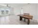 Open-concept living room with tile flooring, a ceiling fan, and two large windows overlooking the backyard pond at 4503 Lindever Ln, Palmetto, FL 34221