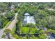 Aerial view of home showcasing a screened-in pool, mature trees, and a well-manicured lawn at 4505 Camino Real, Sarasota, FL 34231
