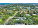 Aerial view of neighborhood with lush landscapes and houses surrounding a beautiful lake at 4505 Camino Real, Sarasota, FL 34231
