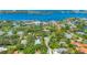 Stunning aerial view showing lush greenery, a glimpse of the marina, and residential neighborhood at 4505 Camino Real, Sarasota, FL 34231