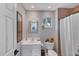 Cozy bathroom with a single sink vanity, framed mirror, and tiled shower with curtain at 4505 Camino Real, Sarasota, FL 34231