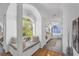 Hallway with arched window leading to well-lit bathroom with garden tub at 4505 Camino Real, Sarasota, FL 34231