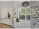 Bathroom with double vanity, pendant lighting, and soaking tub by the window at 4505 Camino Real, Sarasota, FL 34231