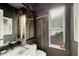 Powder room with unique decorative elements and dark walls contrasting with bright fixtures and a clean white sink at 4505 Camino Real, Sarasota, FL 34231