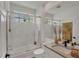 Bright bathroom with a glass shower, vanity with light countertop, and stylish accents at 4505 Camino Real, Sarasota, FL 34231