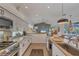 Modern kitchen with stainless steel appliances, a large island, and open layout to the living area at 4505 Camino Real, Sarasota, FL 34231