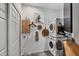 Laundry room with stacked washer and dryer, wooden wall decorations, and natural light from the window at 4505 Camino Real, Sarasota, FL 34231