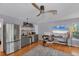 Cozy living room featuring a modern ceiling fan, kitchenette, and ample natural light at 4505 Camino Real, Sarasota, FL 34231