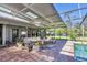 Stylish patio with outdoor furniture, potted plants, and views of the backyard and pool at 4505 Camino Real, Sarasota, FL 34231