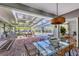 Spacious patio with dining and lounge area, a clear roof, and views of the swimming pool at 4505 Camino Real, Sarasota, FL 34231