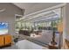 Enclosed patio featuring brick floors and ample seating overlooking the sparkling pool at 4505 Camino Real, Sarasota, FL 34231