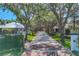 A view of the tree-lined street leading to the home, showcasing the established landscaping at 4505 Camino Real, Sarasota, FL 34231