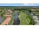 Expansive aerial view showcasing the community, golf course, and water features surrounded by trees at 4505 Kingsmere # 2, Sarasota, FL 34235