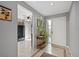 Bright foyer with tile floors, view of the kitchen with black appliances, and a white front door at 4505 Kingsmere # 2, Sarasota, FL 34235