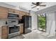 Modern kitchen featuring stainless steel appliances, granite countertops, and access to outdoor patio at 4505 Kingsmere # 2, Sarasota, FL 34235