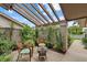 Cozy outdoor patio with comfortable seating, lush greenery, and a pergola shading at 4505 Kingsmere # 2, Sarasota, FL 34235