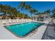 A beautiful outdoor community swimming pool with palm trees and plenty of seating at 4505 Kingsmere # 2, Sarasota, FL 34235