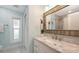 This renovated bathroom features a marble top vanity, new lighting, and a tiled shower at 4665 Pine Harrier Dr, Sarasota, FL 34231