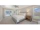 This spacious bedroom features plush carpeting, a ceiling fan, and sliding glass doors to the outside area at 4665 Pine Harrier Dr, Sarasota, FL 34231