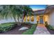 Stunning entrance to the home, surrounded by tropical landscaping and a stone walkway at 4665 Pine Harrier Dr, Sarasota, FL 34231