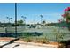 Well-maintained tennis courts with a covered shelter, palm trees, and professional lighting for evening play at 4665 Pine Harrier Dr, Sarasota, FL 34231