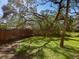 Shady backyard featuring green grass and a wooden fence at 4869 Village Gardens Dr # 189, Sarasota, FL 34234