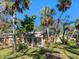 Backyard view highlighting the home's rear facade and lush landscaping with mature trees and a manicured lawn at 4869 Village Gardens Dr # 189, Sarasota, FL 34234