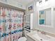 Bright bathroom with white vanity, floral shower curtain, decorative fixtures, and ample natural light at 4869 Village Gardens Dr # 189, Sarasota, FL 34234