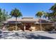 Well-maintained building exterior with palm trees, a red double door, and mature landscaping at 4869 Village Gardens Dr # 189, Sarasota, FL 34234
