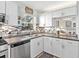 Bright kitchen with stainless steel dishwasher and view to living room at 4869 Village Gardens Dr # 189, Sarasota, FL 34234