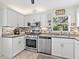 Updated kitchen with white cabinets, stainless steel appliances, and mosaic backsplash at 4869 Village Gardens Dr # 189, Sarasota, FL 34234