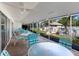 Relaxing covered patio area with multiple tables and chairs overlooking the community pool at 4869 Village Gardens Dr # 189, Sarasota, FL 34234