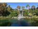Scenic pond with a fountain surrounded by lush greenery and palm trees, creating a serene atmosphere at 4869 Village Gardens Dr # 189, Sarasota, FL 34234