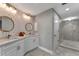 Elegant bathroom with dual sinks, designer wallpaper, and tiled shower with glass door at 501 Haben Blvd # 506, Palmetto, FL 34221