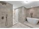 Elegant bathroom with a modern soaking tub, neutral tiles, and a view into the vanity area at 501 Haben Blvd # 506, Palmetto, FL 34221