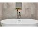 Close-up of a modern soaking tub faucet and decorative wall niche with plants at 501 Haben Blvd # 506, Palmetto, FL 34221