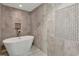 Elegant bathroom with a modern soaking tub, neutral tiles, and decorative wall niche at 501 Haben Blvd # 506, Palmetto, FL 34221