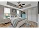 Comfortable bedroom with wood floors, tray ceiling, ceiling fan, and ample natural light from the windows at 501 Haben Blvd # 506, Palmetto, FL 34221