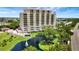Wonderful view of a multi-story luxury building with a tranquil lake and tropical landscaping at 501 Haben Blvd # 506, Palmetto, FL 34221