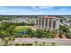 Expansive view of a luxury high-rise building with a pool, pond and lavish landscaping on a sunny day at 501 Haben Blvd # 506, Palmetto, FL 34221