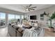 Bright living room features modern ceiling fan, plush grey sofa, and sliding glass doors to a balcony at 501 Haben Blvd # 506, Palmetto, FL 34221