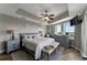 Comfortable bedroom features a tray ceiling, ceiling fan, sitting area, and views from surrounding windows at 501 Haben Blvd # 506, Palmetto, FL 34221