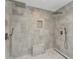 Modern walk-in shower with dual shower heads, pebble floor, bench, and tiled walls at 501 Haben Blvd # 506, Palmetto, FL 34221