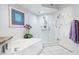 Bathroom featuring a bathtub with glass door shower, white tile, and modern fixtures at 5420 Eagles Point Cir # 106, Sarasota, FL 34231